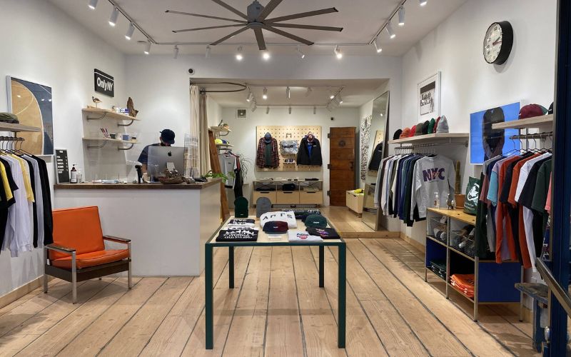 Thiết kế cửa hàng quần áo nam có tông màu tươi sáng, lối đi được bố trí thông thoáng.