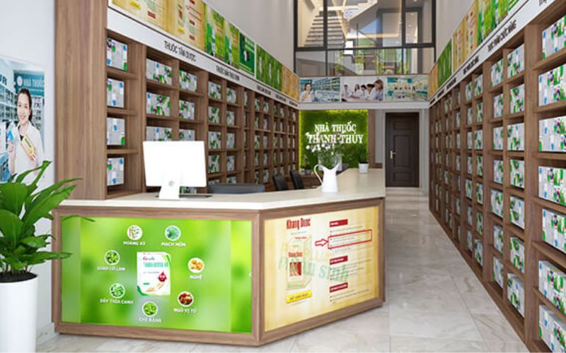 Sự phối hợp giữa kệ tủ trưng bày bằng gỗ cùng với bảng hiệu màu xanh và cây cối trang trí giúp không gian nhà thuốc trở nên gần gũiKhách hàng chắc chắn sẽ cảm thấy thu hút ngay lần đầu bởi thiết kế nổi bật của cửa hàng.