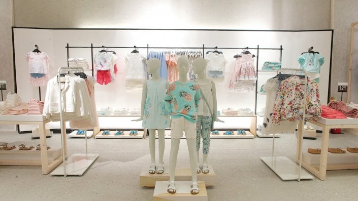 Thiết kế sử dụng gam màu trung tính kết hợp màu pastel của trang phục sẽ tạo nên cảm giá thoải mái dành cho không gian cửa hàng. Tận dụng ma-nơ-canh để trưng bày chính là điểm giúp bạn thu hút được khách hàng hơn khi học có thể hình dung trang phục khi mặc lên sẽ như thế nào, nhất là các bậc phụ huynh không đi cùng con.