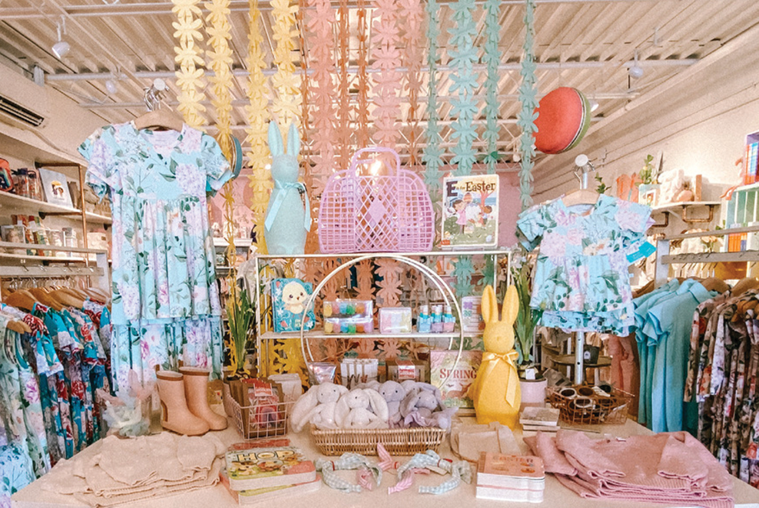 Một gợi ý thiết kế cửa hàng quần áo trẻ em đáng cân nhắc cho chủ shop hướng đến phong cách nữ tính, đáng yêu với váy hoa và những vật trang trí hình gấu ngộ nghĩnh. Thiết kế sẽ là lựa chọn phù hợp cho cửa hàng chuyên cung cấp sản phẩm cho bé gái.